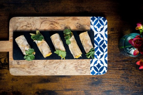 Delicious vegetable and courgette rolls elegantly arranged on a decorative wooden platter with