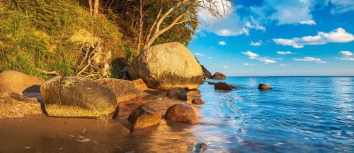 Coastal landscape with large boulders on the Baltic Sea beach in the evening light, Mönchgut Nature
