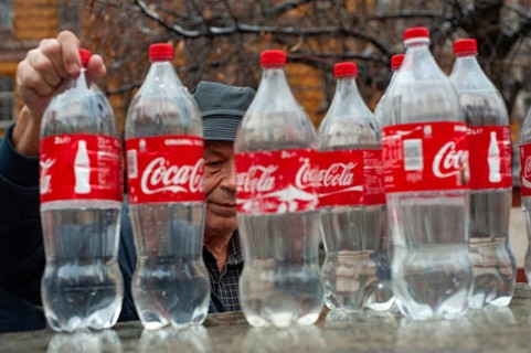 Sofia, Bulgaria. January 21st 2018 An old Bulgarian man filling Coca-Cola bottles with mineral