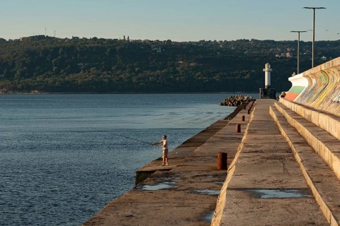 Varna, Bulgaria. September 5th 2020 A man fishing in the Black Sea near the Lighthouse at Varna