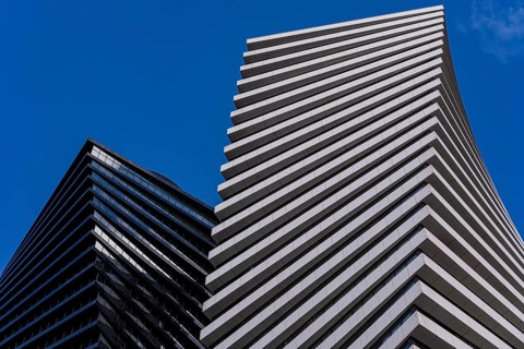 From below striking image of modern architecture showcasing geometric patterns and contrasting
