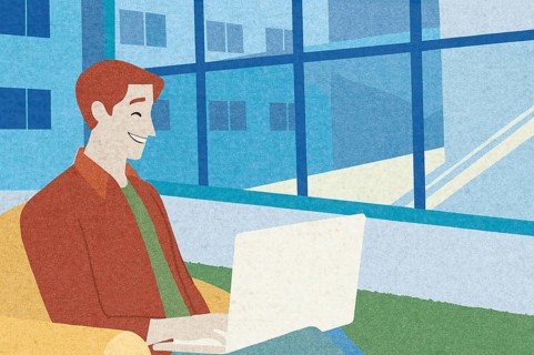 A man sits comfortably on a couch in a modern workspace, smiling while using his laptop The large