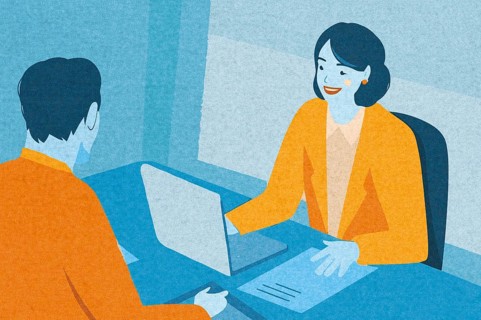 Two professionals engage in a discussion in a contemporary office, with one person using a laptop