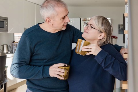 A senior couple, relaxed and happy, enjoying coffee together They share affectionate glances in a