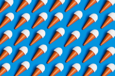 Pattern of plastic ice cream cones on a blue surface, symbolizing the critique of junk food culture