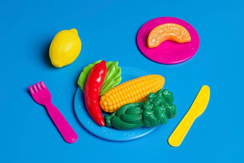 Colorful plastic food portrays junk food culture, critiquing modern diet trends Toys represent