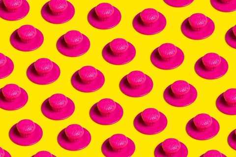 A vibrant pop art-style image featuring pink plastic cupcakes on yellow backgrounds, symbolizing