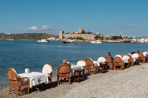 Bodrum, Mugla, Turkey. April 21st 2022 Restaurant Tables on the beach in Bodrum harbour with Bodrum
