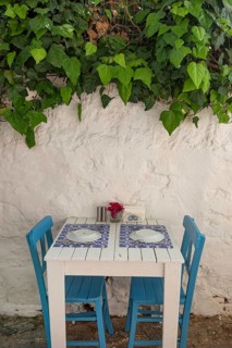 Pretty blue and white cafe restaurant table in a shaded side street in the popular tourist