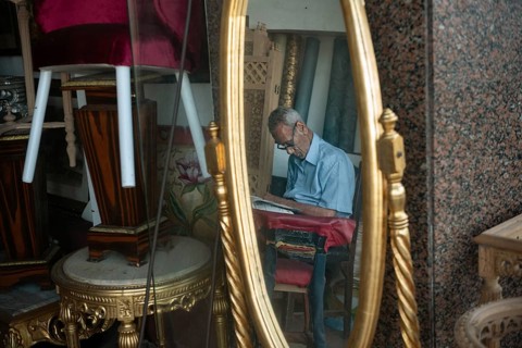 An old man sleeps inside a furniture shop during the summer heat of Alexandria, Egypt
