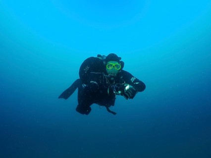 A diver in full gear floats in deep blue water. Giuseppe Dezza wreck dive site, Pula, Croatia,