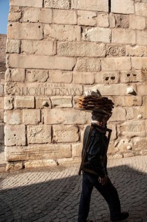 Ankara, Turkey. November 17th 2020 Simit seller walking past old city walls with Roman numerals