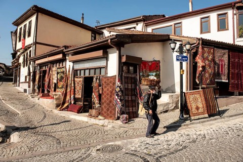 Ankara, Turkey. November 17th 2020 Traditional Turkish Simit seller walking past Antique carpet