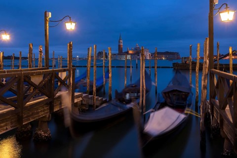 Nighttime atmosphere with moving gondolas, San Georgio Maggiore in the back, Guidecca Island on the