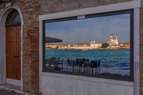 Santa Maria Salute is reflected in a shop window on the island of Guidecca, Venice, Veneto, Italy