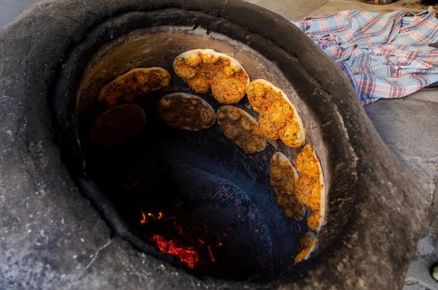 Delicious Turkish Biberli Ekmek Flat bread with red pepper paste cooking in a traditional oven in