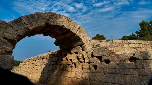 Crypt, vaulted portico, entrance to the stadium, ancient stone arch with shadow cast, surrounded by