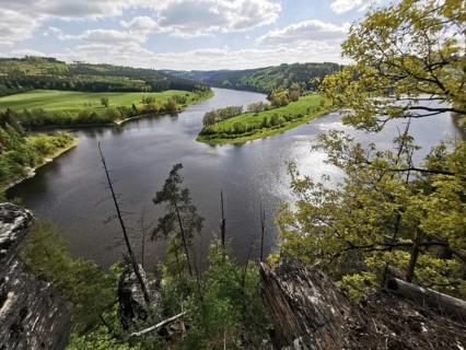 A panoramic view from the Agnesruh viewpoint on a loop of the Saale in the midst of green hills and