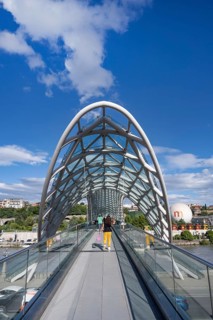 Tbilisi, Georgia. September 12th 2025 Tourists cross The Bridge of Peace over the Kura River also