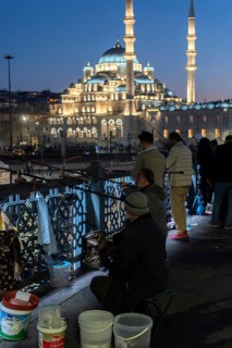 Istanbul, Turkey. January 3rd 2025. Turkish men fishing at night from the Galata Bridge at the