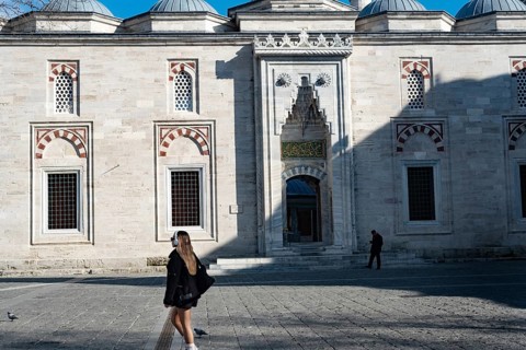 Istanbul, Turkey. January 3rd 2025. A young blond woman walks past a historical mosque near the