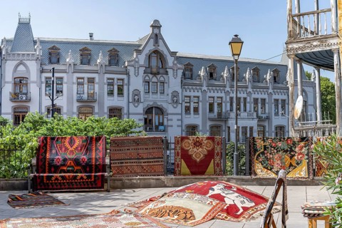 Tbilisi, Georgia. August 5th 2025. Traditional patterned rugs and carpets for sale outside a shop