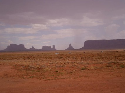 Wide, flat desert landscape with scattered rock formations and cloudy sky, Monument Valley, Navajo