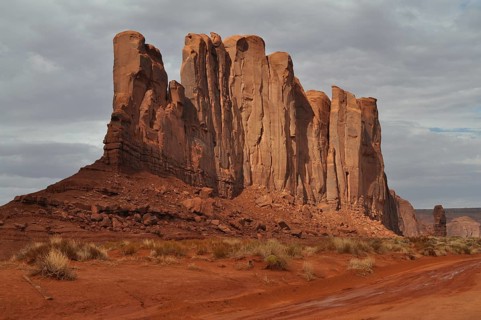 Majestic rocks in bright red rise in a barren desert landscape after a severe thunderstorm,