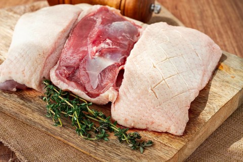 Fresh raw duck breast, on a wooden chopping board, top view, no people