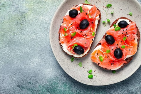 Sandwiches with red fish, cream cheese, olives and microgreens, breakfast