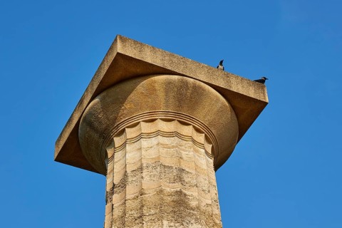 Temple of Zeus, ancient column with two birds on top against a blue sky, archaeological site,