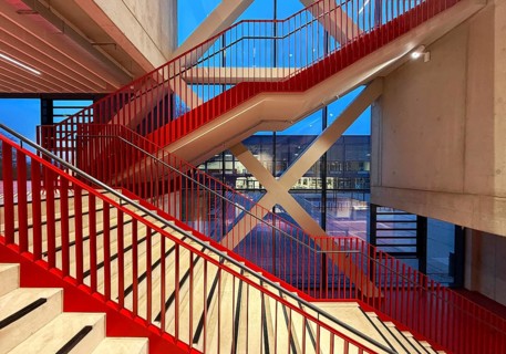 Staircase with signal red color scheme in seminar building H of Bochum University in the evening