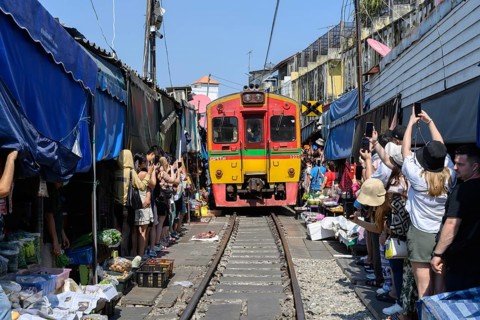 Mae Klong, Thailand. March 15th 2025. Tourists crowd around the arriving 14.30 train as it passes