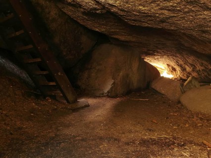 Interior view of a rocky cave, Girgel cave with wooden stairs and light at the end, Franconian