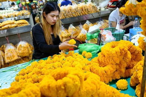 Bangkok, Thailand. March 2rd 2025. A Thai woman making traditional flower garlands at Pak khlong