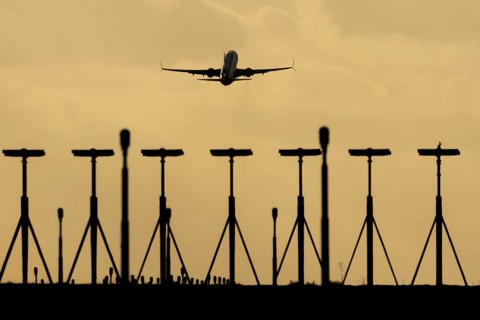 Commercial passenger airliner jet aircraft taking off in flight at sunset at London Stansted