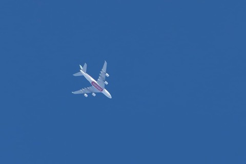 Airbus A380 commercial passenger airliner jet aircraft of Emirates airlines flying in a blue sky,