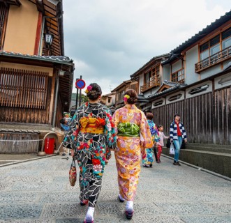 Two Japanese woman wearing kimonos in an alley with traditional Japanese houses, Higashiyama,