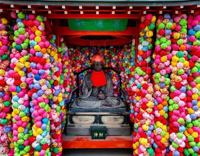 Colorful kukurizaru balls and Buddha statue, Yasaka Koshin-do Temple, Higashiyama, Kyoto, Japan