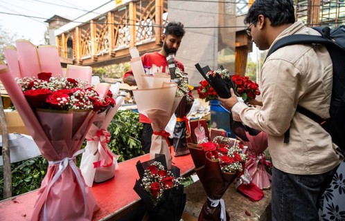 Customers browse red roses and other flowers at a roadside flower shop on Valentine's Day, in