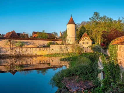 Digestive tower with park guard house on the city wall in morning light, reflection in the