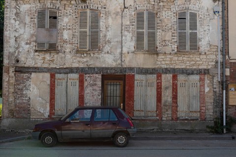 A popular old French car parked outside a typical rural French house in a countryside village in