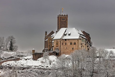 Castle in snow under cloudy sky, no vegetation visible in the foreground, The Wartburg near