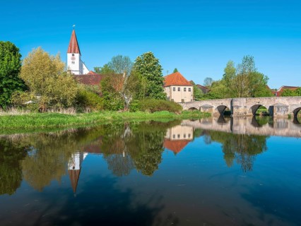 The small village of Ebermergen with church tower and stone bridge, medieval stone bridge over the
