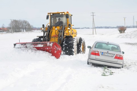 Car stuck in snow gets help from a loader to get free in Skurup municipality, Skåne county, Sweden,