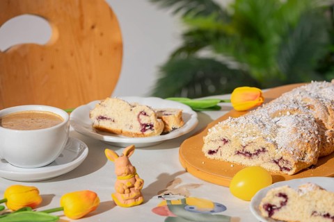 Breakfast table with coffee, sliced yeast braid and decoration for Easter