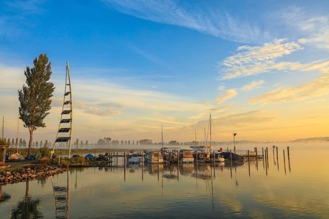 Lake Zell at sunrise with boats on a jetty and a clear sky with clouds, Lake Constance, Höri