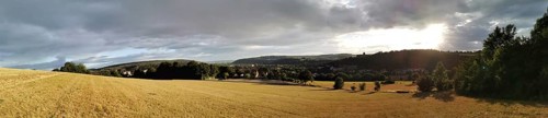 Panoramic landscape at dusk with a wide field and a cloudy sky, Kronach, Frankenwald nature park