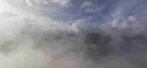 Thick blanket of clouds and fog over a mountain landscape with mystical sky, hiking in the High