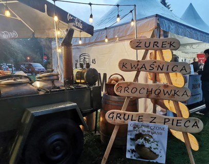 Street vendor with goulash cannon with traditional Polish food at night, illuminated with warm